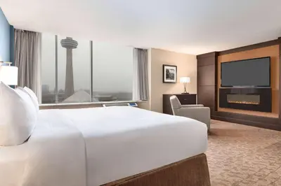 a hotel room with a large white bed and a large window at Wyndham Garden Niagara Falls Fallsview in Niagara Falls
