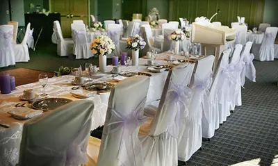 a banquet hall with white tables and chairs with flowers at Hockley Valley Resort in Orangeville