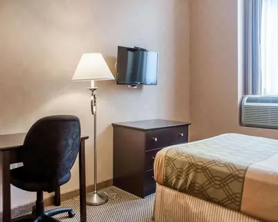 a hotel room with a bed and a desk and a chair at Woodstock Inn and Suites in Woodstock