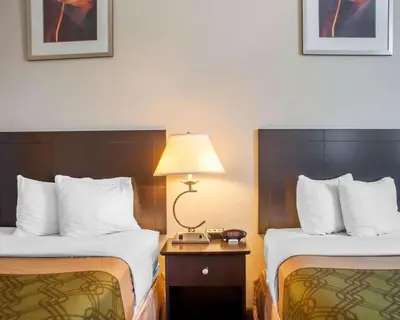 a hotel room with two beds and a lamp at Woodstock Inn and Suites in Woodstock