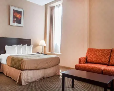 a hotel room with a bed and a chair at Woodstock Inn and Suites in Woodstock