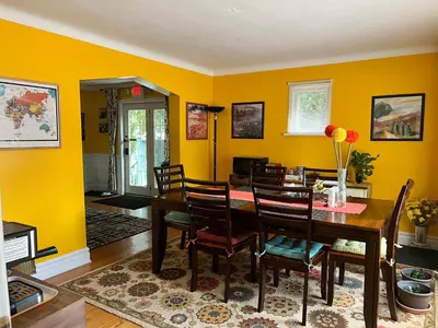 a dining room with yellow walls and a table and chairs at Cozy House B&B in Niagara Falls