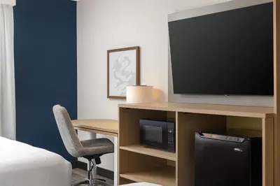a hotel room with a television and a desk with a chair at Spark By Hilton Woodstock in Woodstock