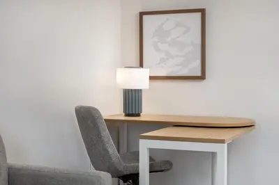 a desk with a lamp and a chair at Spark By Hilton Woodstock in Woodstock
