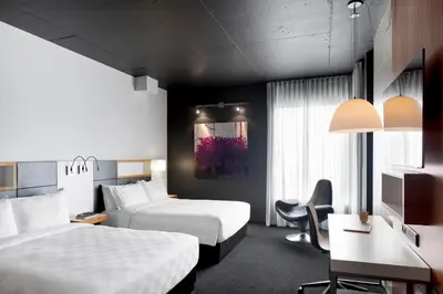 a hotel room with two beds and a desk at Alt Hotel Toronto Airport in Mississauga