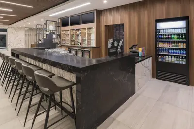a bar with a black counter and stools at Courtyard by Marriott Burlington-Oakville in Burlington