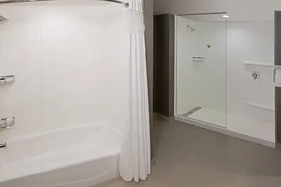 a white bathroom with a tub and a shower at Courtyard by Marriott Burlington-Oakville in Burlington