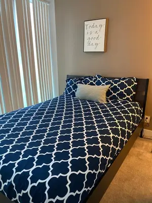 a bedroom with a bed with a blue and white comforter at Stylish Condos Toronto in Toronto