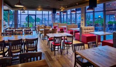 a restaurant with tables and chairs and windows at Waterfront Hotel Downtown Burlington in Burlington