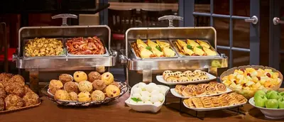 a buffet filled with different types of pastries and food at Waterfront Hotel Downtown Burlington in Burlington