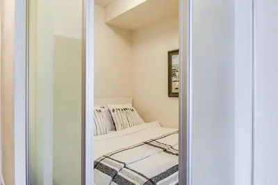 a mirror reflection of a bed in a room at CHOL Furnished Suites Heart of Downtown Toronto, 2 Beds, Free Parking, CN Tower View in Toronto