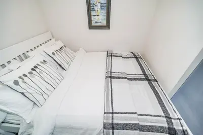 a bedroom with a bed with white sheets and pillows at CHOL Furnished Suites Heart of Downtown Toronto, 2 Beds, Free Parking, CN Tower View in Toronto