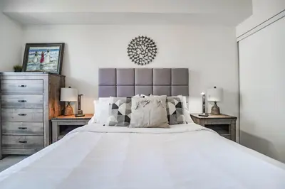 a bedroom with a large white bed with two night stands at CHOL Furnished Suites Heart of Downtown Toronto, 2 Beds, Free Parking, CN Tower View in Toronto