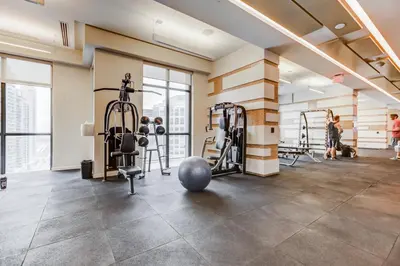 a gym with treadmills and weights in a building at CHOL Furnished Suites Heart of Downtown Toronto, 2 Beds, Free Parking, CN Tower View in Toronto