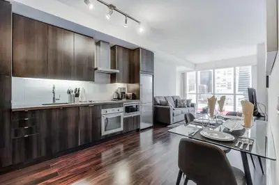 a kitchen and dining room with a table and a dining room at CHOL Furnished Suites Heart of Downtown Toronto, 2 Beds, Free Parking, CN Tower View in Toronto