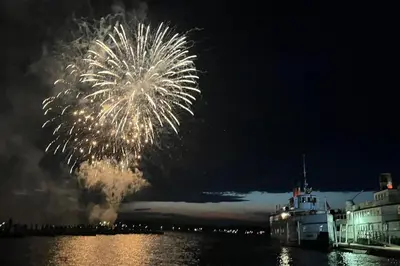 a boat in the water with fireworks in the sky at Blue Spruce Bed and Breakfast Muskoka in Gravenhurst