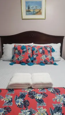 a bed with red and white sheets and pillows at Blue Spruce Bed and Breakfast Muskoka in Gravenhurst