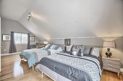a bedroom with two beds and a couch at 6 Bedroom Executive Cottage near Innisfil Beach Park in Innisfil
