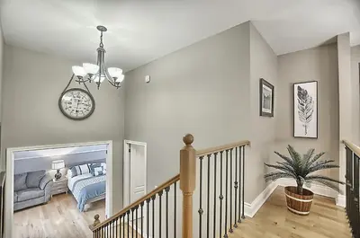 a bedroom with a bed and a clock on the wall at 6 Bedroom Executive Cottage near Innisfil Beach Park in Innisfil