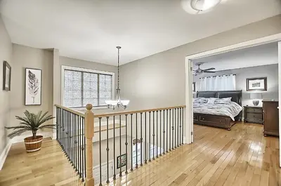 a bedroom with a bed and a wooden floor at 6 Bedroom Executive Cottage near Innisfil Beach Park in Innisfil