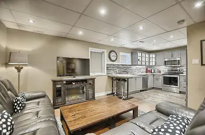 a living room with a couch and a table at 6 Bedroom Executive Cottage near Innisfil Beach Park in Innisfil