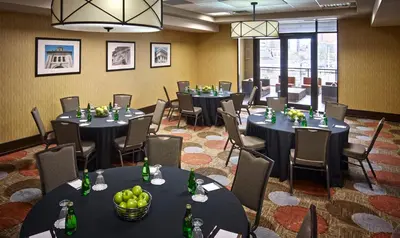 a conference room with tables and chairs with bottles at Staybridge Suites Hamilton - Downtown by IHG in Hamilton