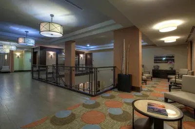 a lobby with a staircase and a waiting room at Staybridge Suites Hamilton - Downtown by IHG in Hamilton