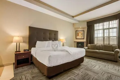 a hotel room with a large bed and a couch at Best Western Brantford Hotel and Conference Centre in Brantford