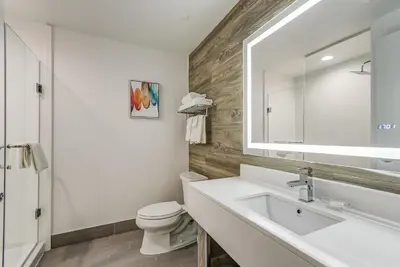 a bathroom with a sink and a toilet and a mirror at EST Hotel in Toronto
