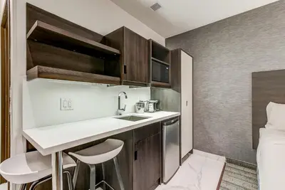 a small kitchen with a sink and a bed at EST Hotel in Toronto