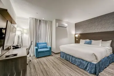 a hotel room with a bed and a blue chair at EST Hotel in Toronto