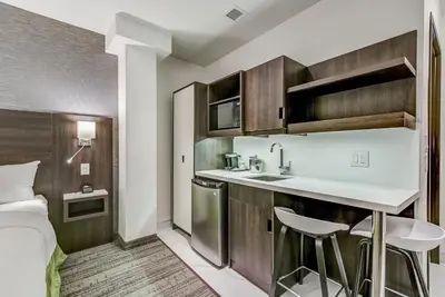 a small kitchen with a sink and a bed in a room at EST Hotel in Toronto
