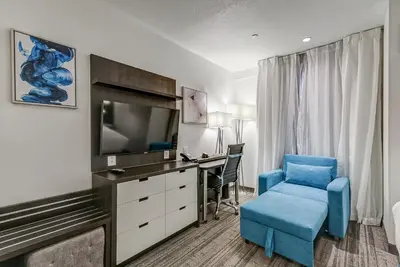 a hotel room with a desk and a blue chair at EST Hotel in Toronto