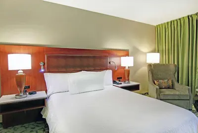 a hotel room with a large bed and a chair at Hilton Garden Inn Toronto/Markham in Thornhill