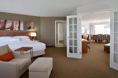a hotel room with a bed and a dining room at Delta Hotels by Marriott Toronto Airport & Conference Centre in Toronto