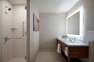 a bathroom with a sink and a shower with a mirror at Delta Hotels by Marriott Toronto Airport & Conference Centre in Toronto