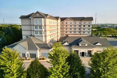 a large building with trees in front of it at Homewood Suites by Hilton Toronto-Markham in Markham
