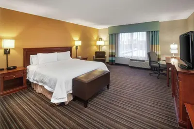 a hotel room with a bed and a flat screen tv at Hampton Inn & Suites by Hilton Toronto Airport in Mississauga