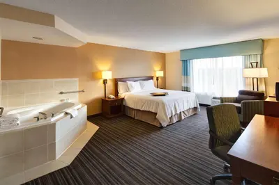 a hotel room with a bed and a bath tub at Hampton Inn & Suites by Hilton Toronto Airport in Mississauga