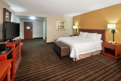 a hotel room with a bed and a flat screen tv at Hampton Inn & Suites by Hilton Toronto Airport in Mississauga