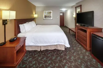 a hotel room with a bed and a flat screen tv at Hampton Inn & Suites by Hilton Toronto Airport in Mississauga