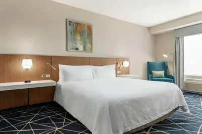 a hotel room with a bed and a chair at Hilton Garden Inn Kitchener/Cambridge in Cambridge