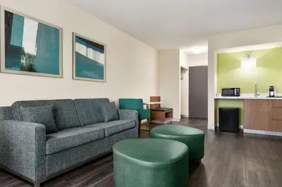 a living room with a couch and two green stools at Hilton Garden Inn Kitchener/Cambridge in Cambridge