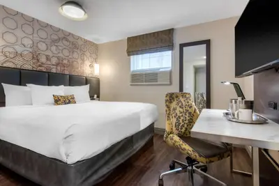 a hotel room with a bed and a desk at The Champlain Waterfront Hotel, an Ascend Collection Hotel in Orillia