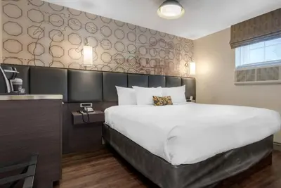 a bedroom with a large bed and a wall at The Champlain Waterfront Hotel, an Ascend Collection Hotel in Orillia