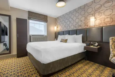 a hotel room with a large bed and a television at The Champlain Waterfront Hotel, an Ascend Collection Hotel in Orillia