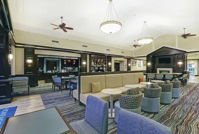 a lobby with tables and chairs and a bar at Homewood Suites by Hilton Cambridge-Waterloo, Ontario in Cambridge