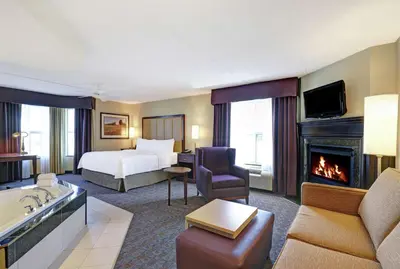 a hotel room with a bed and a fireplace at Homewood Suites by Hilton Cambridge-Waterloo, Ontario in Cambridge