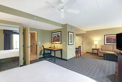 a hotel room with a bed and a living room at Homewood Suites by Hilton Cambridge-Waterloo, Ontario in Cambridge