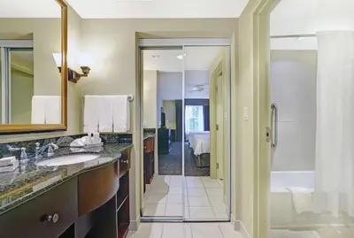 a bathroom with two sinks and a shower and a tub at Homewood Suites by Hilton Cambridge-Waterloo, Ontario in Cambridge